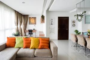 sala de estar con sofá y almohadas coloridas en Float in the Infinity Pool of a Gorgeous Apartment, en Kuala Lumpur