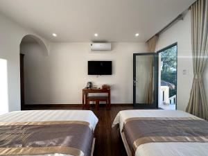 a hotel room with two beds and a tv at An Nam Hue Boutique in Cư Chinh +57 photos