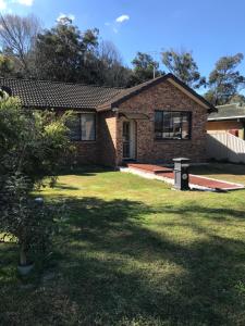 a brick house with a grass yard in front of it at Evans Bed and Breakfast in Lakeside