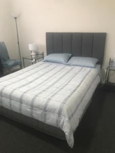 a bedroom with a large bed with a striped comforter at Evans Bed and Breakfast in Lakeside