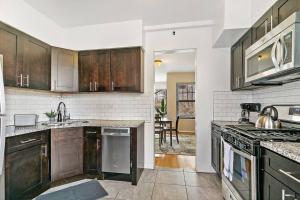 a kitchen with wooden cabinets and a sink and a stove at Beautiful 1BR Brick Home in Historic Hyde Park in Chicago