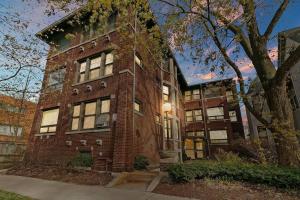 a large brick building with a tree in front of it at Beautiful 1BR Brick Home in Historic Hyde Park in Chicago