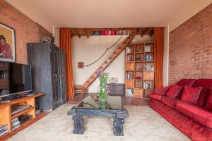 a living room with a red couch and a table at Shivapuri Heights Cottage in Kathmandu