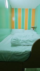 a bed in a room with a striped wall at Ruby Star Hostel Dubai loft Bed Partition G in Dubai