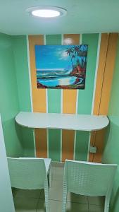 un tavolo e due sedie in una stanza con un dipinto sul muro di Ruby Star Hostel Dubai loft Bed Partition G a Dubai