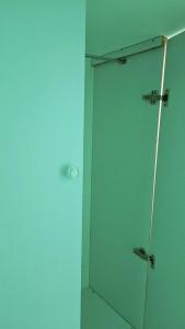 bagno con cabina verde e specchio di Ruby Star Hostel Dubai loft Bed Partition G a Dubai