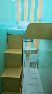 a dorm room with a bed and a table and a chair at Ruby Star Hostel Dubai loft Beds G in Dubai