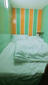 a large bed in a room with green and orange stripes at Ruby Star Hostel Dubai loft Beds G in Dubai