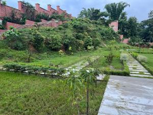 un jardín con una colina al fondo en Yahiya en Sylhet