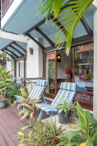 a patio with two blue chairs on a deck at Khaolak Oriental Resort - Adult Only in Khao Lak