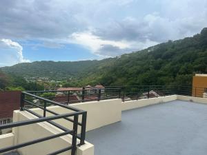 a balcony with a view of a mountain at Luxury Penthouse Suit Red Hills in Kingston