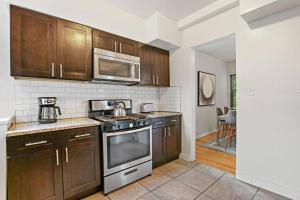 una cocina con electrodomésticos de acero inoxidable y armarios de madera en Charming 3BR Chicago Apt in Prime Location, en Chicago