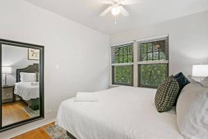 Habitación blanca con cama y espejo en Charming 3BR Chicago Apt in Prime Location, en Chicago