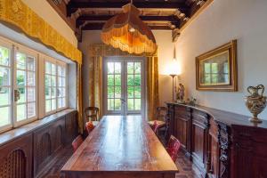 uma sala de jantar com uma mesa de madeira e janelas em Villa Colle em Ossuccio