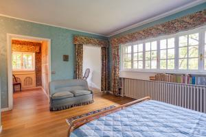 um quarto com uma cama, uma cadeira e janelas em Villa Colle em Ossuccio