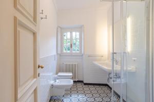 a white bathroom with a toilet and a sink at Villa Colle in Ossuccio +40 photos