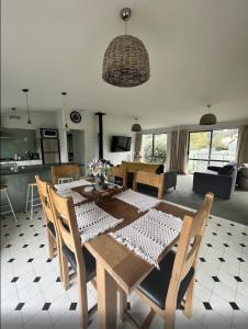 a dining table and chairs in a living room at Kapanga Escape in Coromandel Town