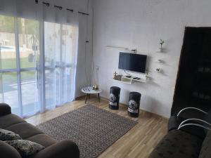 un soggiorno con divano e TV di Chácara dos Silva a Santa Isabel