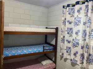 a room with bunk beds with a shower curtain at Chácara dos Silva in Santa Isabel