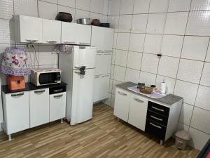 a small kitchen with a refrigerator and a microwave at Chácara dos Silva in Santa Isabel