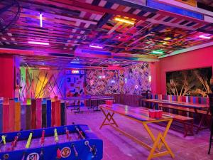 uma sala com mesas de pingue-pongue e luzes roxas em iHome Hoi An em Hoi An