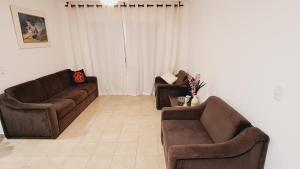 sala de estar con 2 sofás marrones en Av Brasil 100m do Shopping e garagem privativa, en Balneário Camboriú