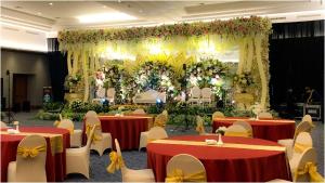 a banquet hall with red and yellow tables and flowers at Hotel Ayola Sunrise Mojokerto in Mojokerto