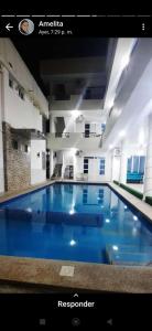 a large blue swimming pool in a building at Hostería Luz Del Mar in Tonsupa