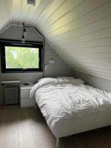 a small bedroom with a bed and a window at Lykkja - Beautiful Waterfront House in Viggja