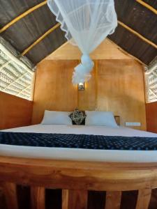 a bedroom with a bed with a white canopy at Pidurangala View Treehouse in Sigiriya