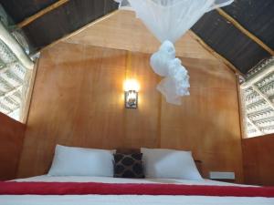 ein Schlafzimmer mit einem Bett in einer Holzwand in der Unterkunft Pidurangala View Treehouse in Sigiriya