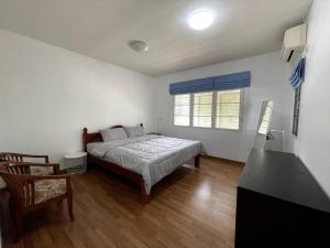Schlafzimmer mit einem Bett, einem Schreibtisch und einem Fenster in der Unterkunft K house in Ban Bang Khen (1)
