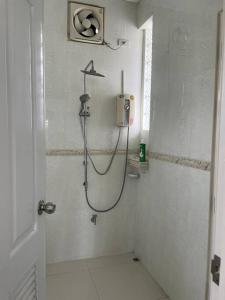 La salle de bains blanche est pourvue d'une douche avec un tuyau. dans l'établissement K house, à Ban Bang Khen (1)