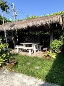 - un pavillon avec une table de pique-nique et un toit en gazon dans l'établissement K house, à Ban Bang Khen (1)