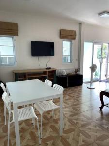 - une table et des chaises blanches dans le salon dans l'établissement K house, à Ban Bang Khen (1)