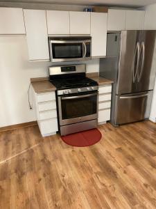 a kitchen with a stove and a microwave and a refrigerator at Windsor Airport Accommodation in Windsor