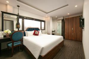 a bedroom with a bed and a desk and a chair at La Renta Premier Hotel & Spa Hanoi in Hanoi