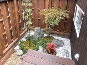 a garden with rocks and plants in front of a fence at Asuka no yado-明日香の宿- in Asuka