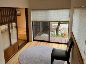 sala de estar con silla y ventana en Asuka no yado-明日香の宿-, en Asuka