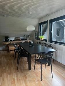 een eetkamer met een zwarte tafel en stoelen bij Lykkja - Beautiful Waterfront House in Viggja