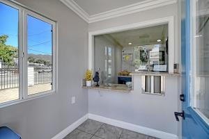 een badkamer met een wastafel en een groot raam bij White Caps Motel in Ventura