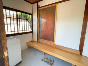 a room with a window and a wooden bench at Asuka no yado-明日香の宿- in Asuka