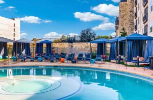 uma piscina num hotel com cadeiras e mesas em Cozy Retreat-Free Reserved Parking-Pool em Addison