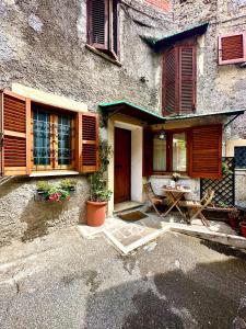an old house with wooden shutters and a table in front of it at LA GROTTA in Subiaco