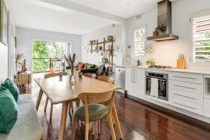 uma cozinha e sala de jantar com mesa e cadeiras em 'Bronte Beauty' Modern Heritage Style with Balcony em Sydney