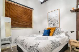 a bedroom with a bed and a window with blinds at The Stylist's House - A Chic Inner City Landmark in Sydney