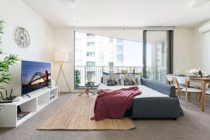 a bedroom with a bed and a table and a large window at 'The Peak' Resort-style Balcony Abode in the Metro in Sydney