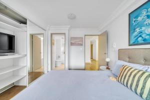 une chambre avec un grand lit et une télévision dans l'établissement Urban Sky Terrace in the Vibrant Heart of Sydney, à Sydney