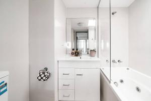 une salle de bain blanche avec un lavabo et un miroir dans l'établissement Urban Sky Terrace in the Vibrant Heart of Sydney, à Sydney 29 autres photos