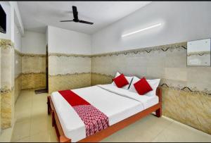 a bedroom with a bed with red pillows at RK RESIDENCY INN in Chennai